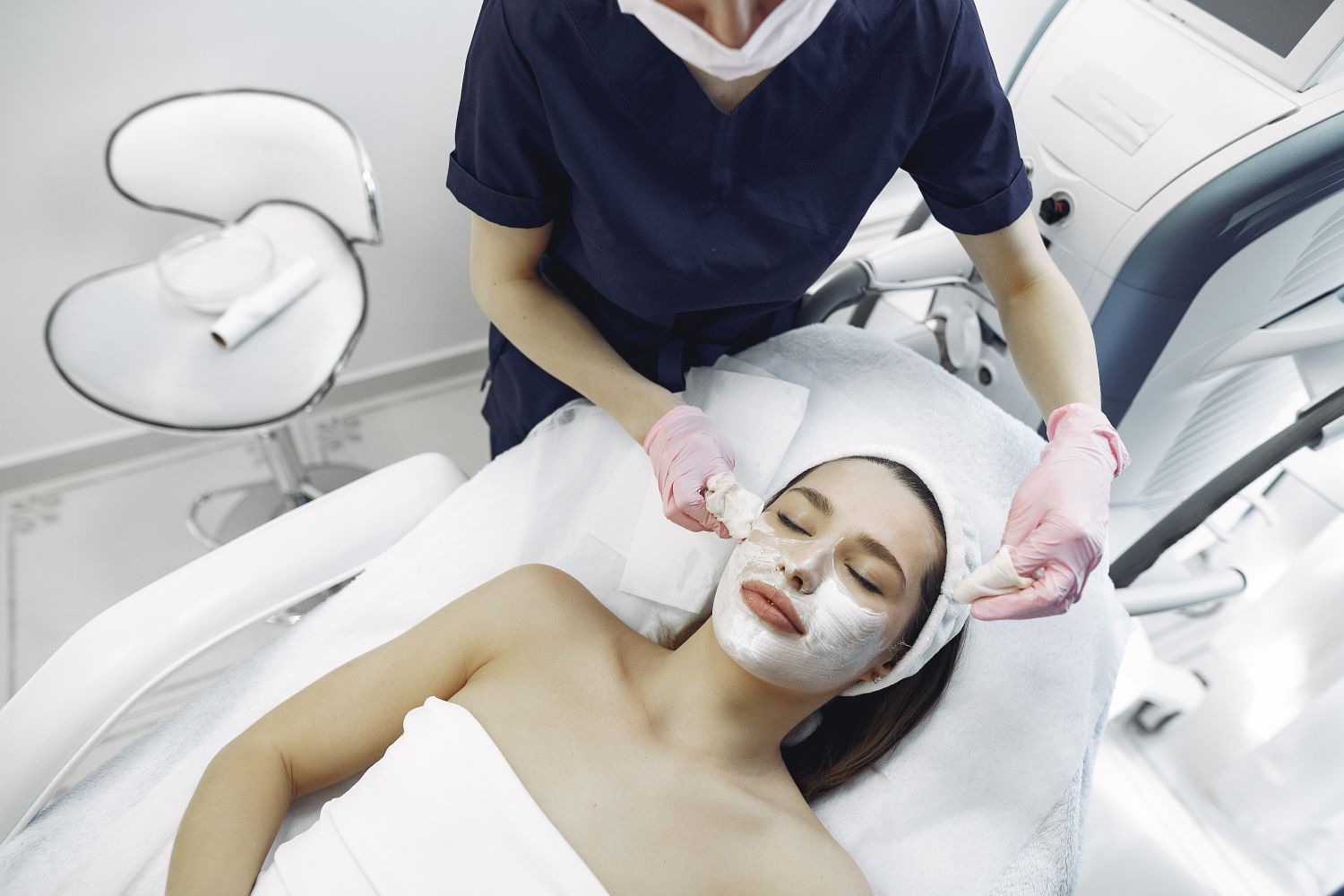 A licensed esthetician performing a facial treatment in a clinic